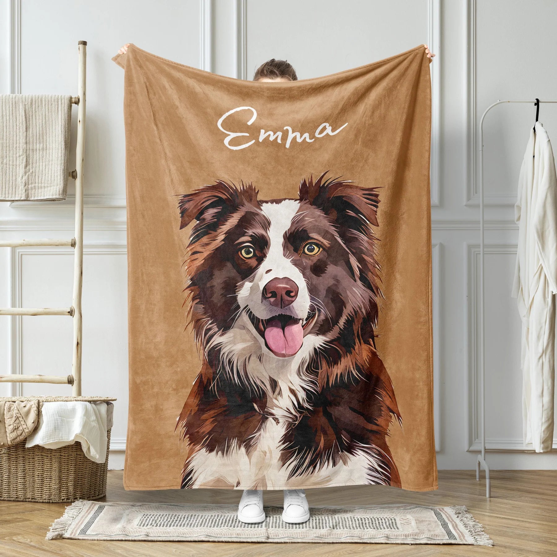 Brown blanket with a dog illustration and 'Emma' text held by a person in a room.